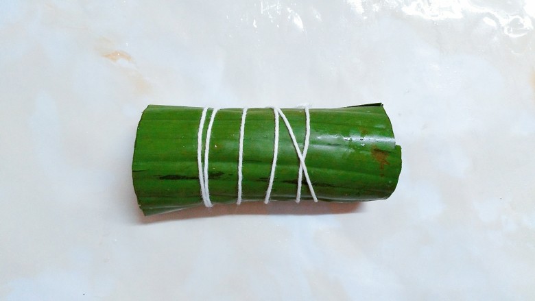 芭蕉叶黑糯米骨,然后用棉绳缠紧芭蕉叶,打死结!