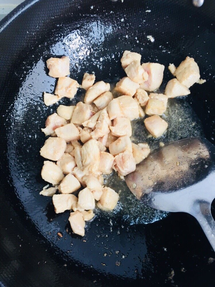 彩椒炒鸡丁,炒锅倒油烧热,下鸡肉丁滑熟,盛出备用。