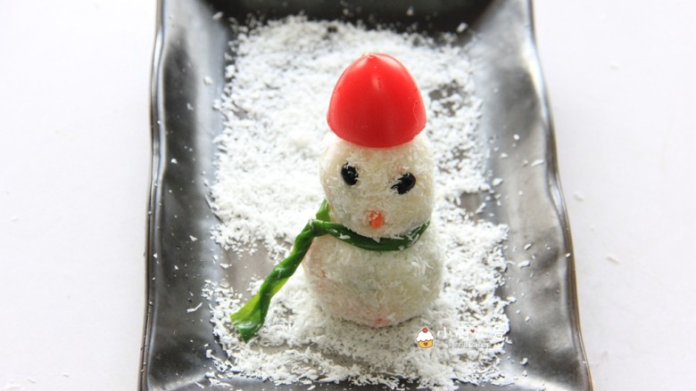 满足孩子想堆雪人的愿望---土豆雪人,接下来把两个圆球拼接在一起,用黑豆作为眼睛,胡萝卜作嘴,切半个<a style='color:red;display:inline-block;' href='/shicai/ 3438'>圣女果</a>作为帽子,韭菜当作雪人的围巾,这样一个小雪人就做好啦