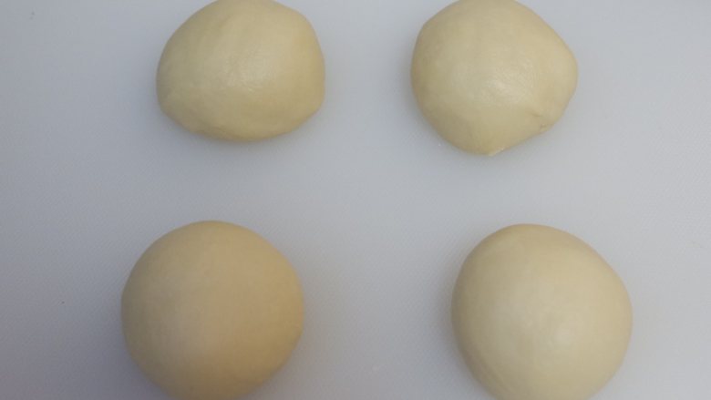 豆沙面包卷,平均分成4份,滚圆,盖上保鲜膜松弛10分钟。