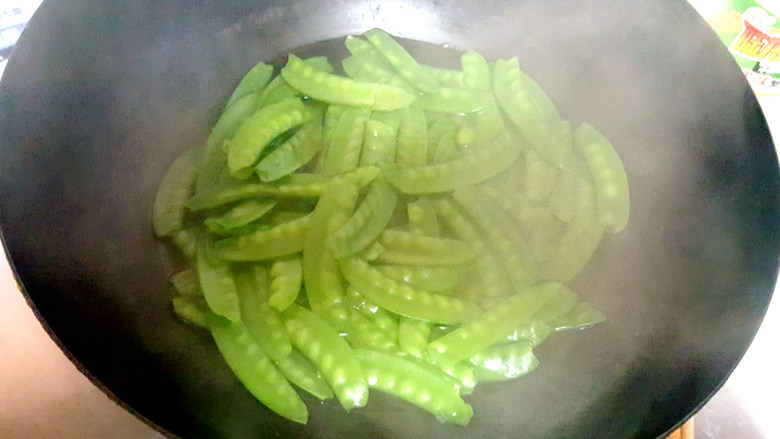 荷兰豆炒香肠,荷兰豆放在沸水中汆水,加少许盐。