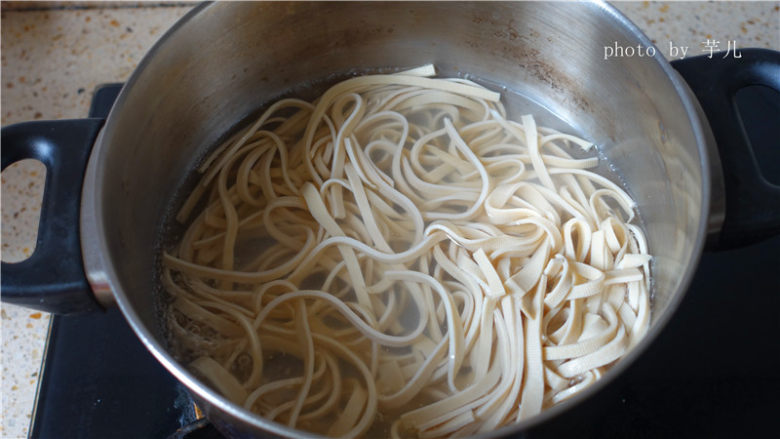 凉拌豆腐丝,锅中加入适量的清水烧开后放入豆腐丝煮一下。捞起来,滤干水份备用。