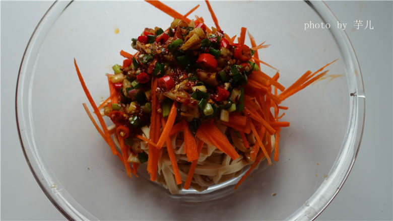 凉拌豆腐丝,将拌好的作料淋在豆腐丝上面,翻拌均匀,撒上香菜,装盘,