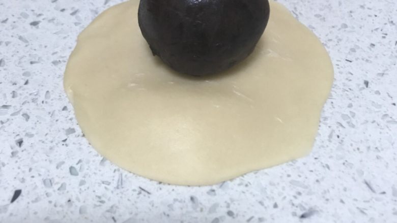 蛋黄酥,擀成边缘薄,中间厚的面饼,包入蛋黄豆沙馅。