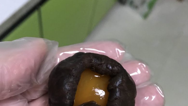 蛋黄酥,用右手虎口向上推,直到把整个蛋黄包住,口收紧。