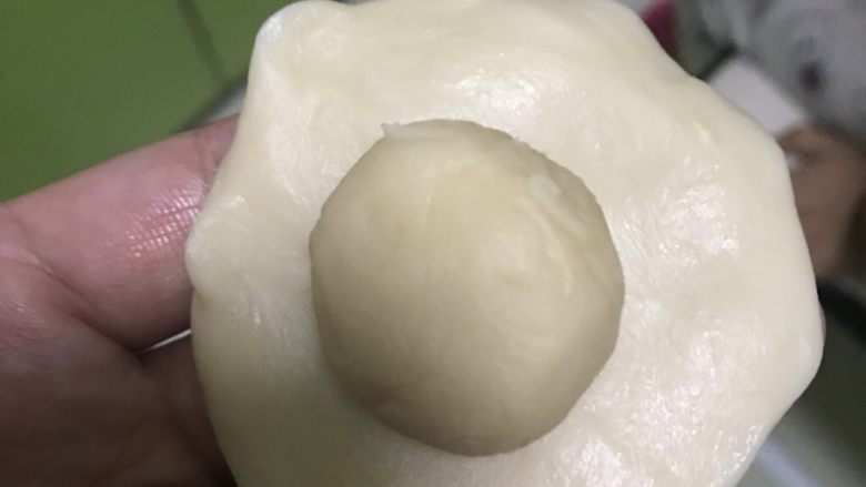蛋黄酥,分好后,取油皮一份压成中间厚边缘薄的饼,油酥放中间。