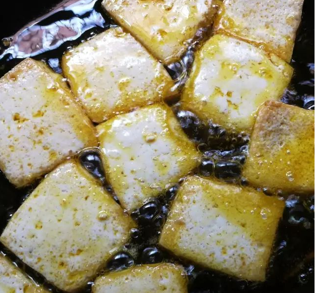 黄金豆腐烩,食用油8成熟下豆腐煎至两面金黄起锅沥油