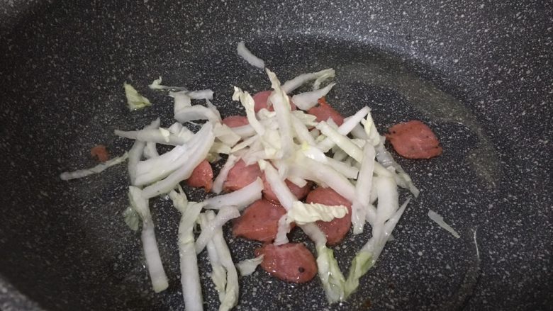 杂锦炒面,锅中倒入适量油,把热狗肠倒入爆香后放入白菜一起翻炒
