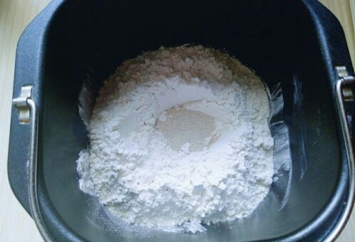 原味水立方吐司面包,最后再面粉的顶端挖个小洞,(不要挖到液体) 把酵母粉倒入挖好的洞洞里。再用旁边的面粉将酵母粉盖上。