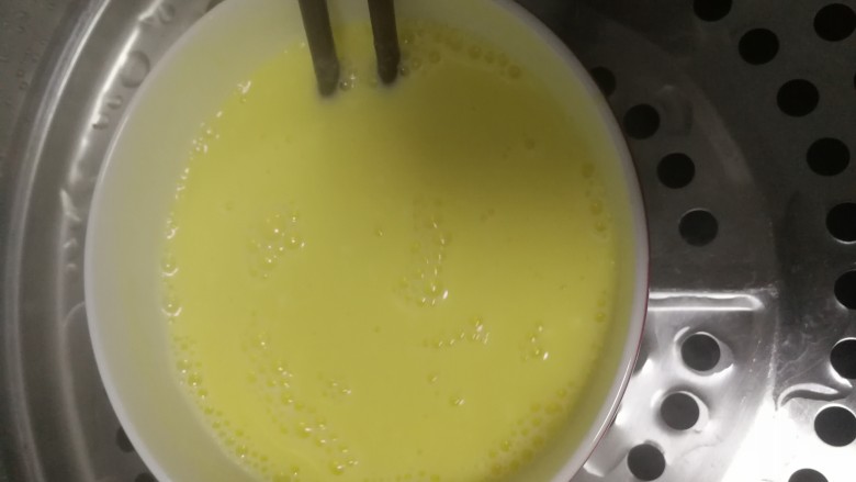 小朋友最爱的零食之：牛奶布丁,倒入牛奶和蛋黄搅匀，放入球球糖，小火慢慢蒸，中间要不断搅匀。