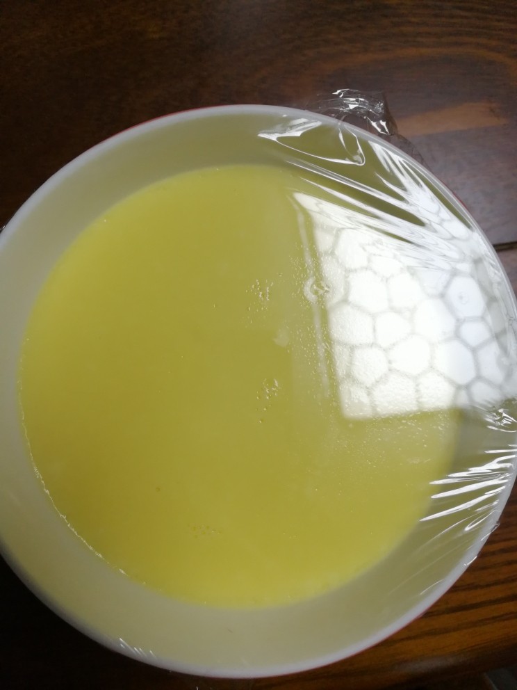 小朋友最爱的零食之：牛奶布丁,把蒸好的牛奶慢慢倒入熬好的糖里边。容器放入保鲜膜，放入冰箱冷藏两个小时，