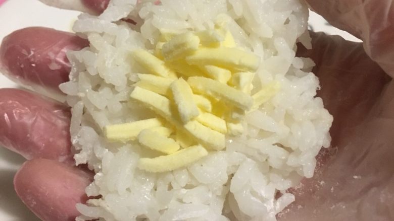 黄金芝士饭团,戴手套打开一份饭团
捏扁
中心放入芝士
包起来