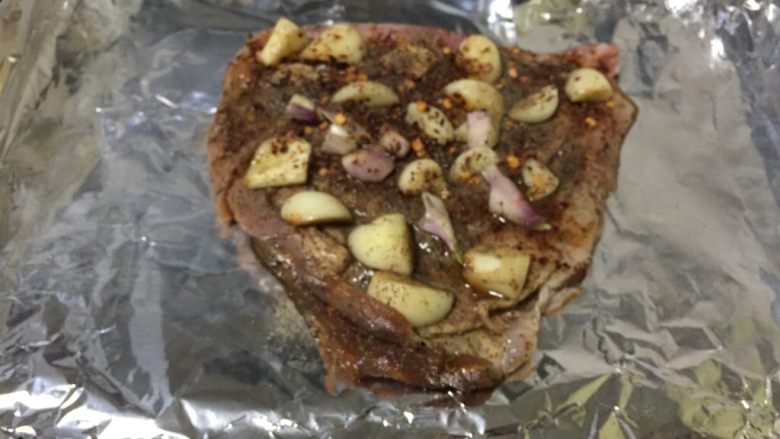 烤羊排,烤盘上铺一张锡纸,将腌制好的羊排将酱汁到淋在羊排上