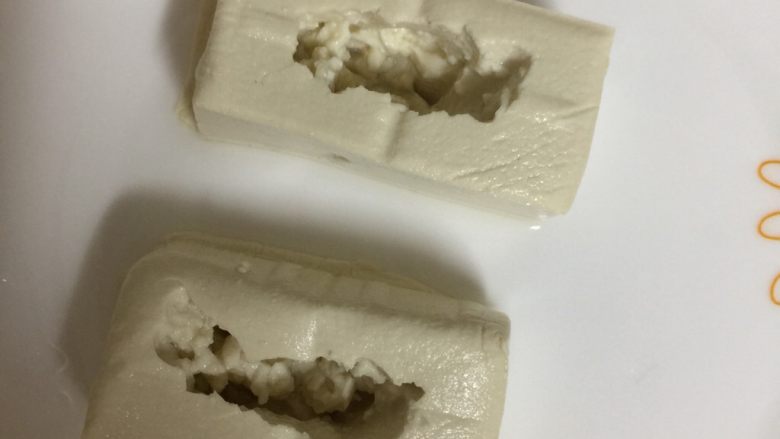 客家酿豆腐,接着用铁勺子抠掉中间的一小部分豆腐,注意两边不要太薄了,薄的话容易烂,可以挖深一些下去,这样肉可以装多一些
