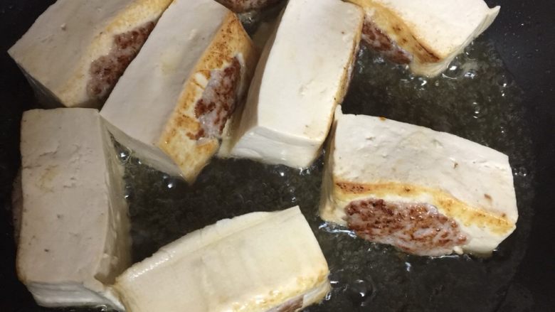 客家酿豆腐,煎到像这个颜色就差不多了,接着煎两侧,左右两边先煎至金黄色