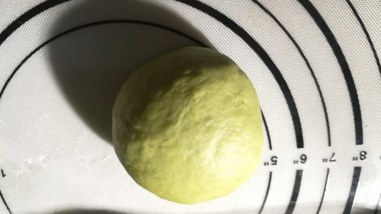 一次发酵的抹茶奶酪包,整一下形状,尽量滚圆,收口向下。