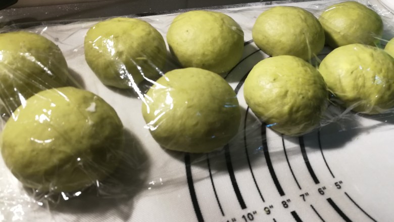 一次发酵的抹茶奶酪包,10个全部包好以后,盖上保鲜膜进行发酵,大约50分钟。
