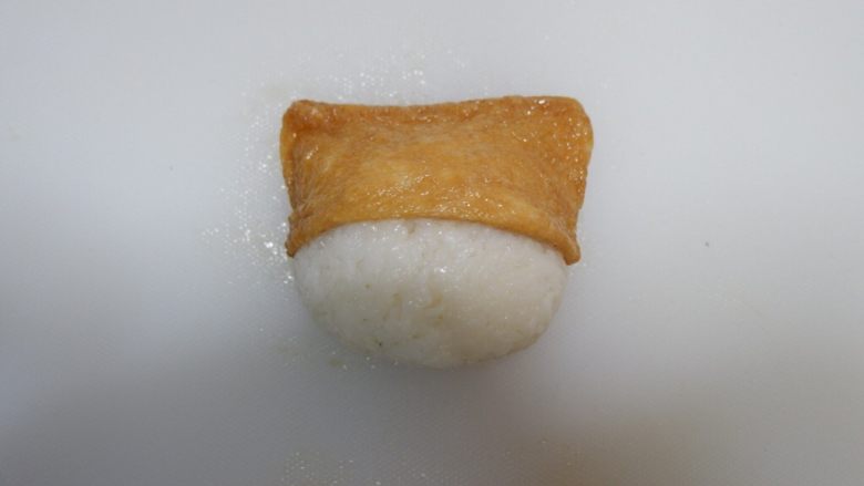 卡通睡帽小熊便当「13」,打开做好的饭团,将豆腐包套在饭团上。睡帽小熊就完成了。