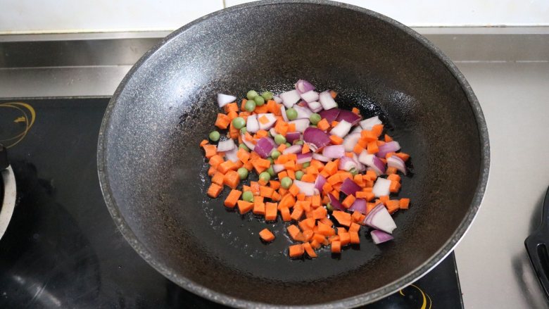 泰式咖喱鱼蛋,热锅冷油,先下胡萝卜、洋葱、豌豆翻炒