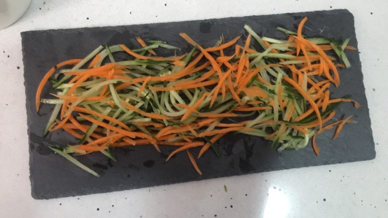 咖喱寿司,在石板上铺上胡萝卜丝和黄瓜丝