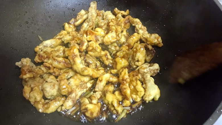 糖醋里脊,汤汁粘稠后调小火,倒入炸好的里脊肉条,翻拌至均匀的粘上汤汁