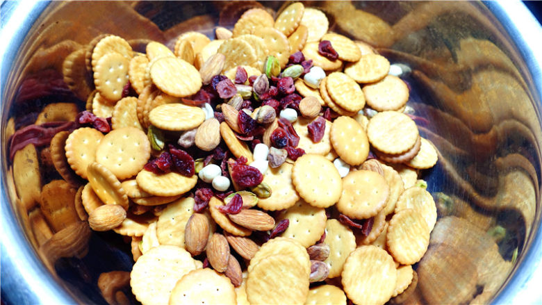 网红雪花酥,<a style='color:red;display:inline-block;' href='/shicai/ 109174'>蔓越莓干</a>切成小块,将小奇福饼干和烤香的干果放在一起,混合均匀,因为后面这几种材料是一起倒进锅里的。整形用的金盘也要放在旁边,因为整形动作越快越好,不然到后面,糖慢慢凝固了就不好整形了。