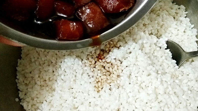 鲜肉粽子,将泡好的糯米沥水,把腌鲜肉的汤汁倒进糯米中,拌匀。
