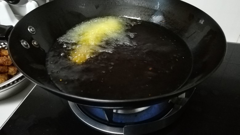 秘制油炸肉丸,用手抓一把肉泥,挤出一个小团,小勺子挖下放入油锅里