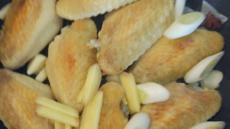 可乐鸡翅,继续煎至金黄，放入大葱、生姜、大蒜、茴香、桂皮、八角