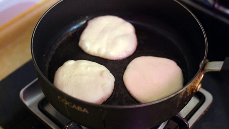 陕西小吃—肉夹馍,锅内倒油,将醒发好的面团放入其间煎至双面金黄。