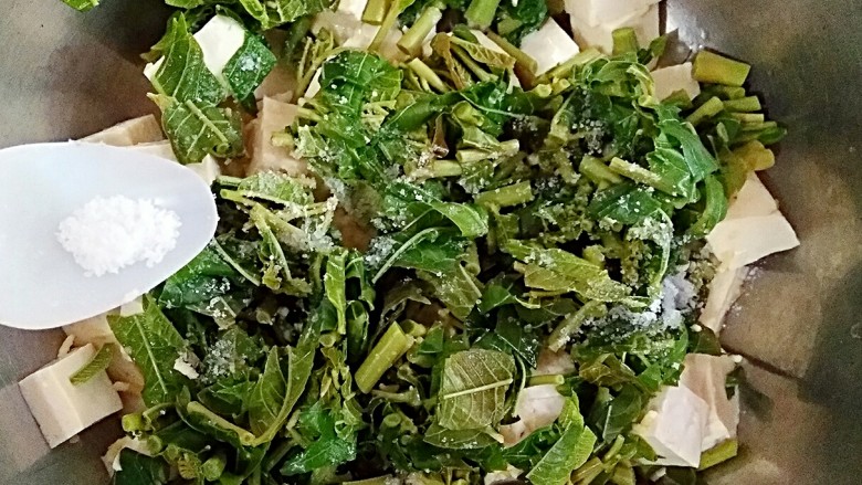 香椿拌豆腐,将切好的豆腐和香椿芽放入容器,撒上适量盐。