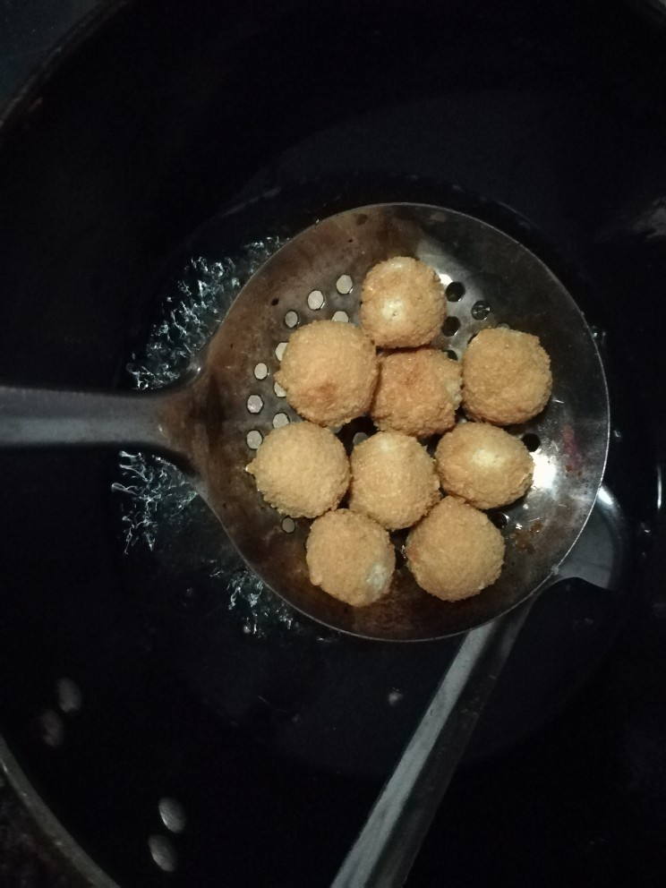 鸟巢豆腐丸子沙拉,油锅六成热的时候,将豆腐丸子炸金黄,出锅。