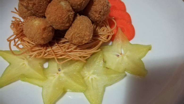 鸟巢豆腐丸子沙拉,将豆腐丸子摆在炸好的面条上面,下面是鸟巢,上面当做鸟蛋。