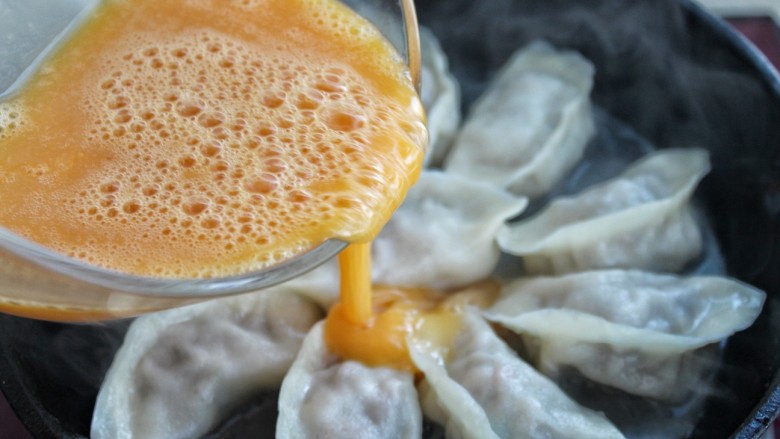 抱蛋煎饺,待锅中的水分快要收干时,从锅边淋入蛋液