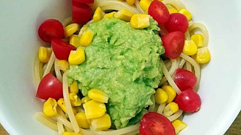 牛油果Pasta,将煮好的意面控水之后捞出加入少量橄榄油拌匀,然后放至室温左右时,加入牛油果酱,小番茄和甜玉米粒拌匀。