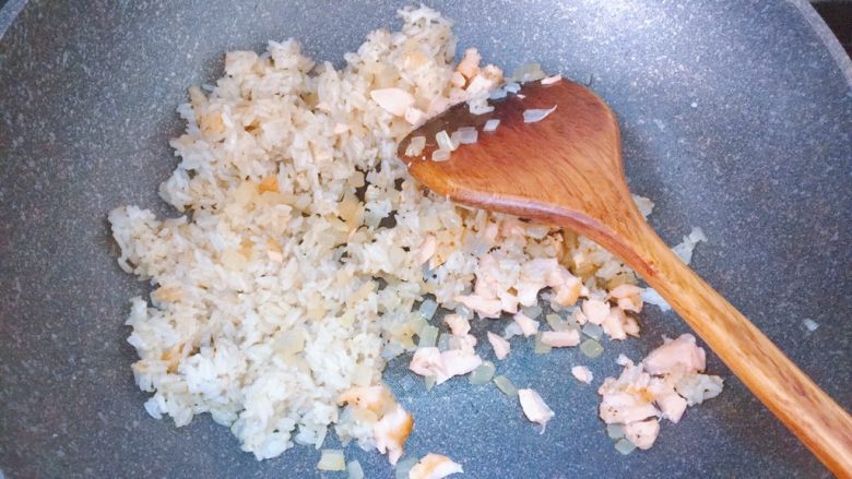 黑椒牛油果三文鱼炒饭,倒入洋葱和三文鱼,翻炒均匀