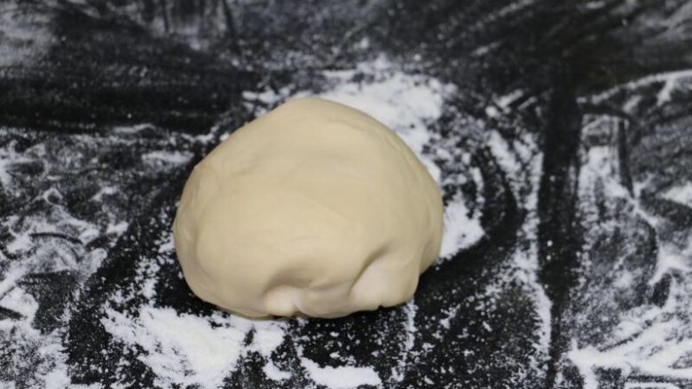 自制美味肉酱手擀面,然后在案板上撒粉,把面团放上去