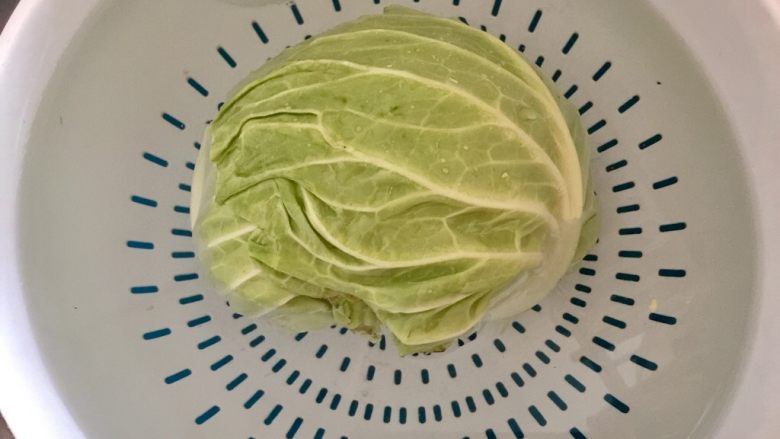 朴素的美味➕猪油渣包菜炒粉丝,洗菜盆中接清水,放入少许食盐,放入包菜切口朝下浸泡