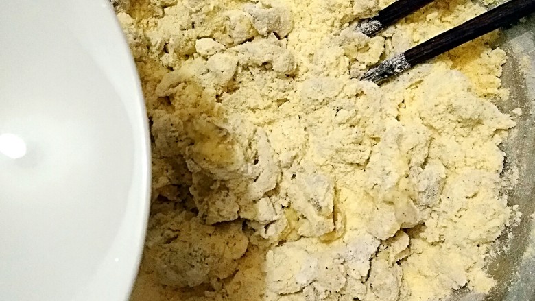 虾酱杂粮窝窝头,在混合好的杂粮粉中少量多次加入温水,用筷子搅拌成雪花状,揉成面团。