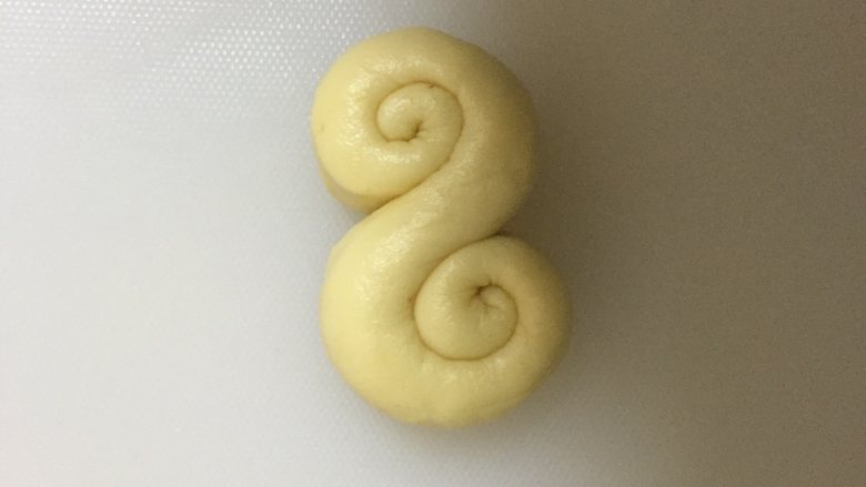蔓越莓拧花面包,搓成长条,两头反方向卷起来,整形成像图片这样。