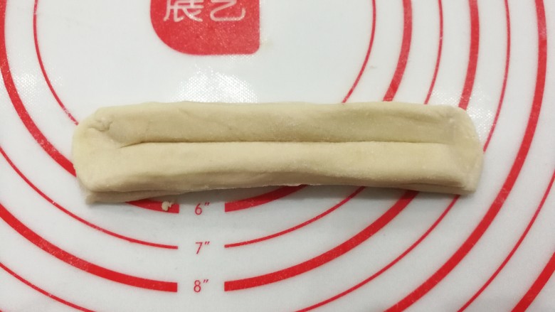 自制健康小油条,然后两头捏紧捏扁,顺势把面块拉伸长一些;