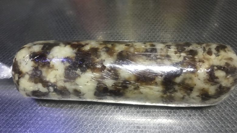 老北京清真小吃-糖卷果,最后将卷好的卷果放到保鲜膜上,两头打结裹紧,晾凉。我一般会将卷好的卷果放入冷藏室冷藏,第二天拿出来继续下一步。