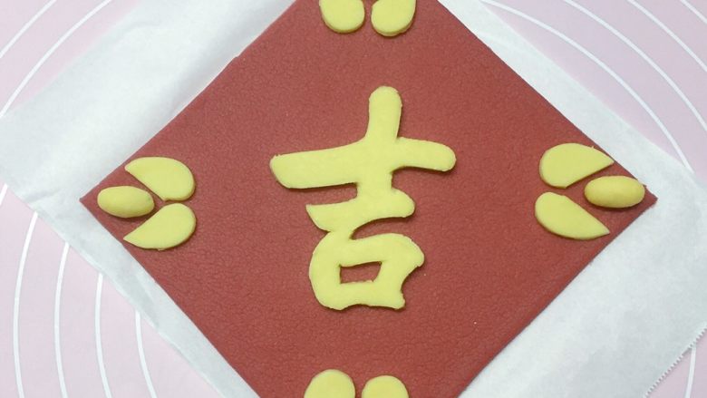 吉祥如意,如图:将切开的心形和小圆球摆放在红色方块面片的四个角边。
