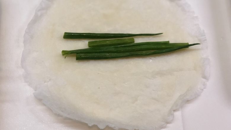 葱包烩儿,取一张皮,在中心放上几段小葱