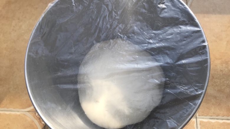 创新美味肉包子,面团放在干净的容器里,覆盖保鲜膜放置在暖和的地方进行发酵,冬天发酵的时间比较长哦,这个时候有充足的时间来准备包子馅。