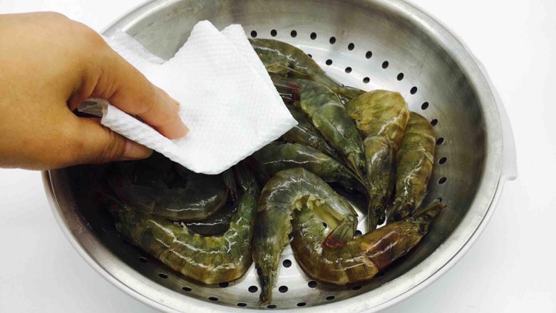 油焖糖醋大虾,用厨房用纸吸干水份,放2g的盐腌制10分钟。