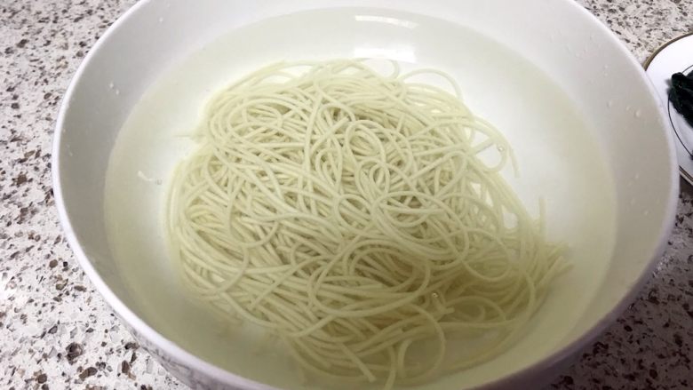 鸡丝汤面,捞出长寿面,放入冷开水中,立即捞出