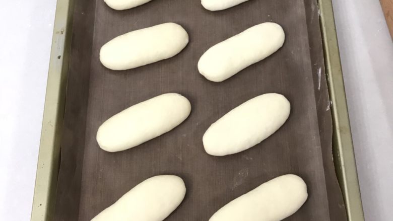芝士香葱热狗面包,摆放在烤盘中,送入发酵箱,温度在34度湿度保持在80%左右二发