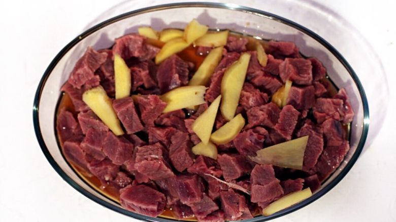 黑椒牛肉松,浸泡好的牛肉用水冲洗净放入盆中,加入50毫升<a style='color:red;display:inline-block;' href='/shicai/ 718'>料酒</a>和少许姜片腌制30分钟。