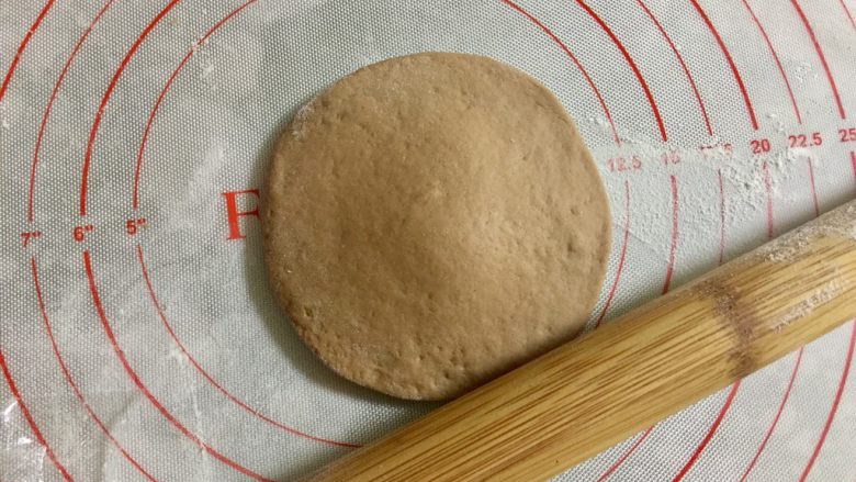 萌萌哒小猴子奶黄包,取其中一小份可可面团,搓圆按扁,擀成圆形。